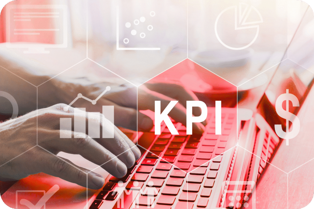 Mãos digitando em um laptop com uma sobreposição gráfica futurista em tons de vermelho, destacando um hexágono com a sigla KPI (Key Performance Indicator) no centro. O gráfico inclui ícones de análise de dados, gráficos de barras e um símbolo de dólar ($), representando o uso de métricas financeiras e de desempenho.